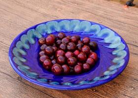 Berries of a sweet cherry in a blue plate. Ripe red sweet cherry photo