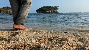 Woman's feet step on the beach with a vast ocean landscape photo