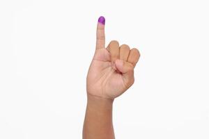 Close up of hand gesture little finger after voting. General elections or Pemilu for the president and government of Indonesia. The finger dipped in purple ink. Isolated image on white background photo