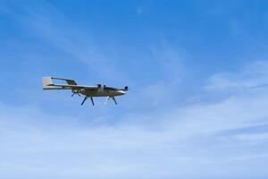 DIY Unmanned Aerial Vehicle made by college student, flying through the air against the sun photo