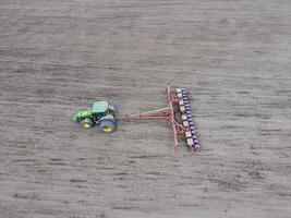 siembra de maíz. tractor con un sembradora en el campo. utilizando un sembradora para plantando maíz. foto