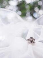 Diamond engagement wedding rings on bridal veil. Wedding accessories. Valentine's day and Wedding day concept. photo
