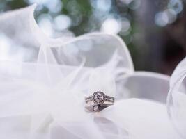Diamond engagement wedding rings on bridal veil. Wedding accessories. Valentine's day and Wedding day concept. photo