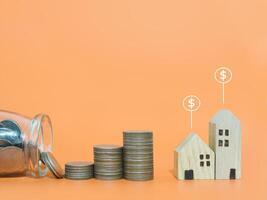 Miniature house with Dollar coin icons and stack of coins. The concept of price of house, Property investment, House mortgage, Real estate photo