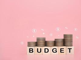 Wooden blocks with the word BUDGET on stack of coins. The concept about budget planning and allocation photo