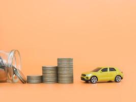 Toy cars and stack of coins. The concept of saving money and manage to success transport business photo