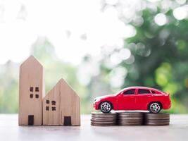 Miniature house and wooden toy car on stack of coins. The concept of saving money  for car and house photo