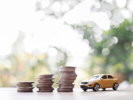 Toy car and stack of coins. The concept of saving money and manage to success transport business photo