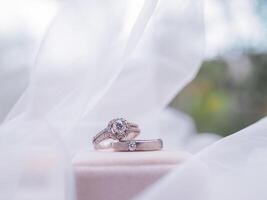 Diamond engagement wedding rings on bridal veil. Wedding accessories. Valentine's day and Wedding day concept. photo