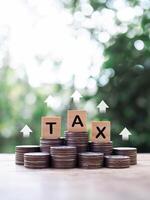 Wooden blocks with the word TAX on stack of coins. The concept about saving money and manage time to paying tax photo