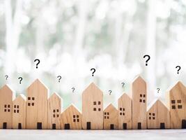 Miniature house with question mark icons.The concept of choosing suitable house for planning living in the future. Real estate photo