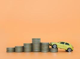 Toy car and stack of coins. The concept of saving money and manage to success transport business photo