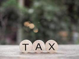 Wooden blocks with the word TAX. The concept of prepare to pay tax. photo