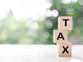 Wooden blocks with the word TAX. The concept of prepare to pay tax. photo