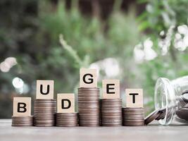 Wooden blocks with the word BUDGET on stack of coins. The concept about budget planning and allocation photo