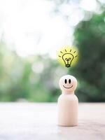 Wooden business figure with light bulb for leadership, creative, idea, innovation concept. photo