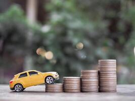 Toy cars on stack of coins. The concept of saving money and manage to success transport business photo