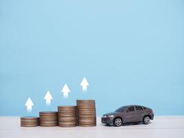 Toy car, stack of coins with arrow rising. The concept of business growth, saving money and manage to success transport business photo