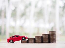 Toy cars on stack of coins. The concept of saving money and manage to success transport business photo