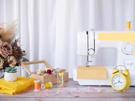 Close up sewing machine working with yellow fabric, sewing accessories on the table, stitch new clothing. photo