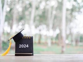 Study goals, 2024 Desk calendar with graduation hat. The concept for Resolution, Goal, Action, Planning, and manage time to success graduate. photo