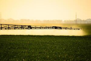 chorros de líquido fertilizante desde el tractor pulverizador. foto