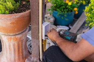 Electrician installing switches and sockets box on the metal pole. photo