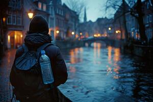 AI generated A man with backpack carrying reusable water bottle walking by canal. Generative AI. photo