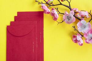 Top view of Chinese New Year red packet and cherry blossom decoration with customizable space for text or wishes. Chinese New Year celebration concept photo