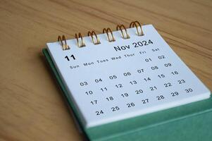 Close up side view of November 2024 calendar on wooden desk. Calendar concept photo