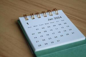 Close up side view of January 2024 calendar on wooden desk. Calendar concept photo