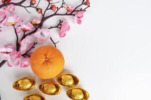 Top view of Mandarin oranges and golden ingot with customizable space for text or greetings. Chinese New Year concept photo