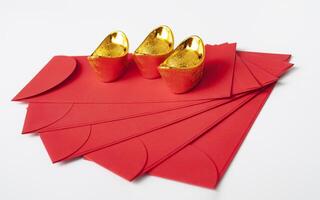 Chinese New Year red packet and golden ingot on white cover. Chinese New Year celebration concept. photo
