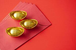 Golden ingot on top of red packets. Chinese New Year celebration concept photo