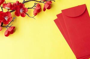 Top view of Chinese New Year red packet and cherry blossom with customizable space for text or wishes photo