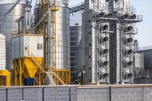 silos and agro-processing plant for processing for drying cleaning and storage and seed preparation complex in snow of winter field photo