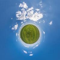 simple tiny planet without buildings in blue sky with beautiful clouds. Transformation of spherical panorama 360 degrees. Spherical abstract aerial view. Curvature of space. photo