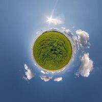 simple tiny planet without buildings in blue sky with beautiful clouds. Transformation of spherical panorama 360 degrees. Spherical abstract aerial view. Curvature of space. photo