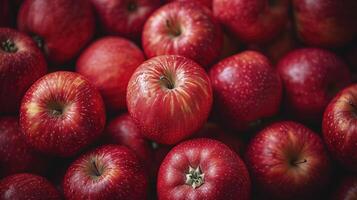 ai generado rojo manzanas fondo, mojado con agua gotas, son apilado dentro un grande envase y fotografiado desde arriba. foto