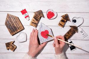 mujer dibujo corazón en de madera casa, elaboración, paso por paso instrucciones cómo a hacer decoración para san valentin, madres día foto