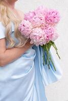 bride in a blue wedding dress with a bouquet of pink peonies, pastel paradise photo