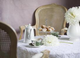 té descanso en Inglés estilo, Clásico todavía vida, hecho en casa bollos, un ramo de flores dalias foto