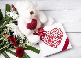 Valentine's day gift, teddy bear with a heart, a box of pralines and a bouquet photo