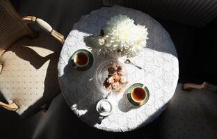 English style tea break, still life with flowers and donuts in the morning sun photo