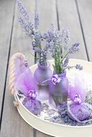 Lilac lavender in vases and lavender sachets,chiffon bags on a tray,still life photo