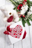 Valentine's day gift, teddy bear with a heart, a box of pralines and a bouquet photo