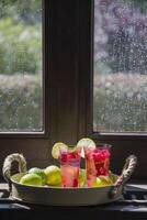 Refreshing raspberry and lime lemonade in pink glasses on the windowsill photo