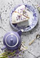 still life with black tea and cheese cake, spring bouquet,delicate lilac flowers photo