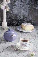 still life with black tea and cheese cake, spring bouquet,delicate lilac flowers photo