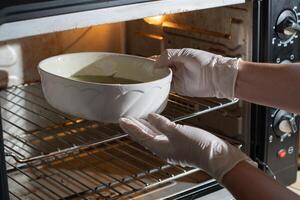 woman baked spinach muffin step by step,puts the form with the dough in the oven photo